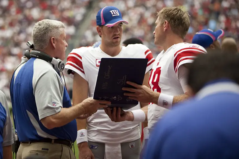 Eli Manning reviews notes on 10/10/2010 with offensive coordinator Kevin Gilbride and backup quarterback Sage Rosenfels. Houston Texans Vs. New York Giants. Reliant Stadium. Houston, Tx. Oct. 10, 2010 Photo by AJ Guel. www.ajguel.com