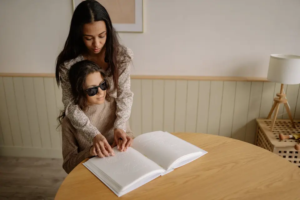 Photo by Yan Krukau: https://www.pexels.com/photo/a-woman-helping-a-blind-person-read-a-braille-book-7694427/