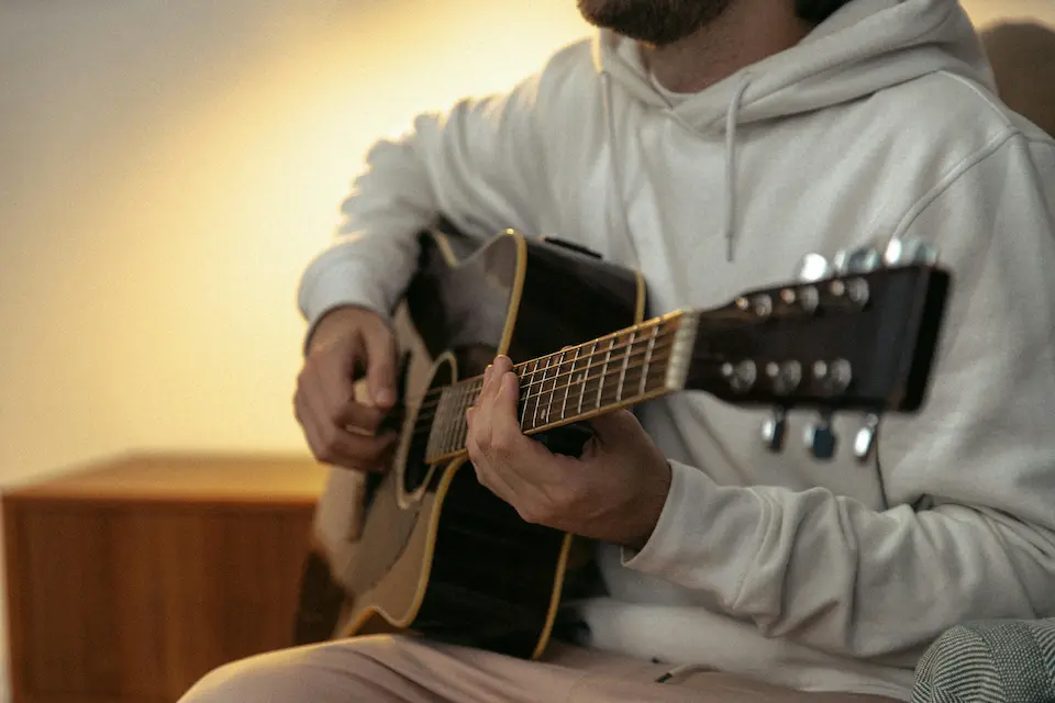 Photo by SHVETS production: https://www.pexels.com/photo/a-person-playing-a-guitar-8929514/