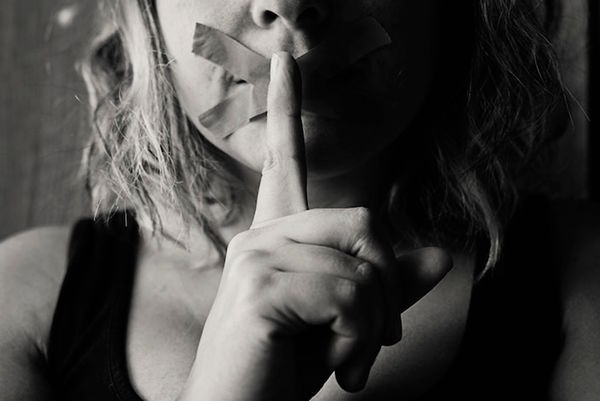 Photo of woman with tape over her mouth by Kat Jayne